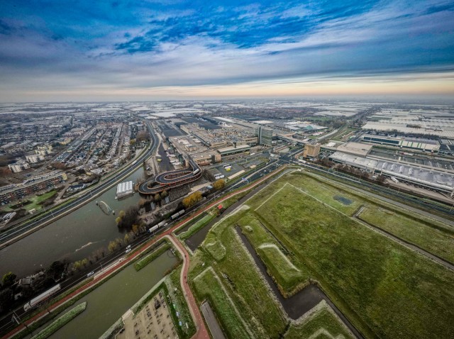 Een birds eye view van Westland met weilanden, wegen, bedrijven, woningen en vaarwegen in de provincie Zuid-Holland